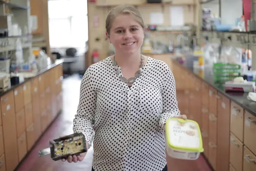 Andrea Hicks displaying Keuric coffee maker in one hand and nanosilver plastic food storage in her other hand.