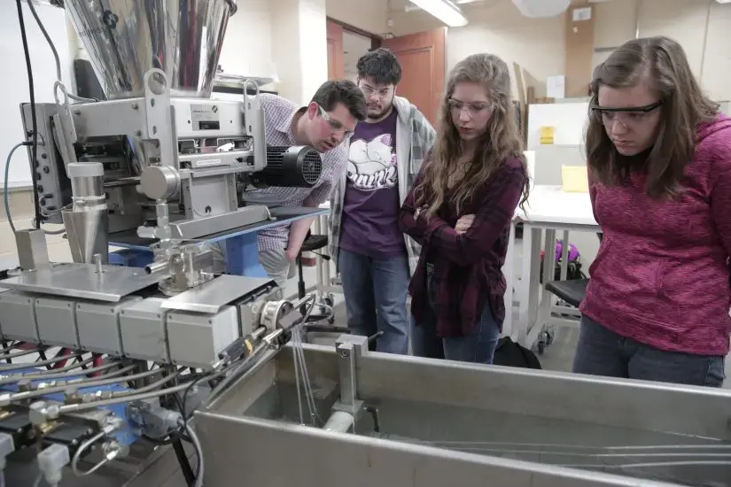 Students looking into the extruder