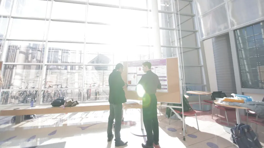Student in atrium with many windows and sun shinning in from behind