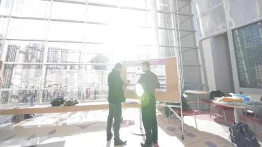 Student in atrium with many windows and sun shinning in from behind