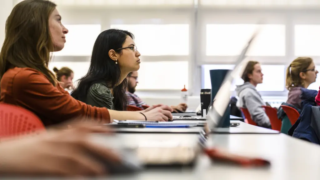Graduate students listen and take notes on their laptop computers during a Hydroclimatology for Water Resources Management class taught by Paul Block