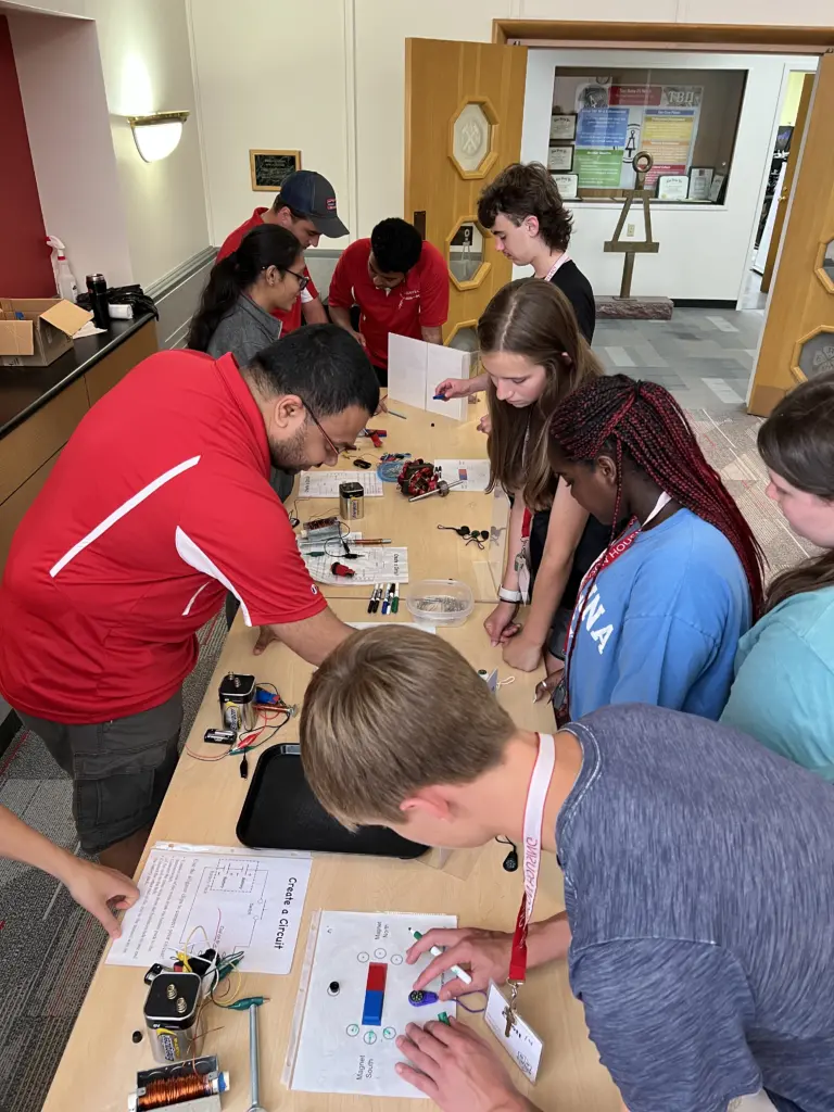 Middle and high school students interact with electromagnetic displays set up by ECE graduate students
