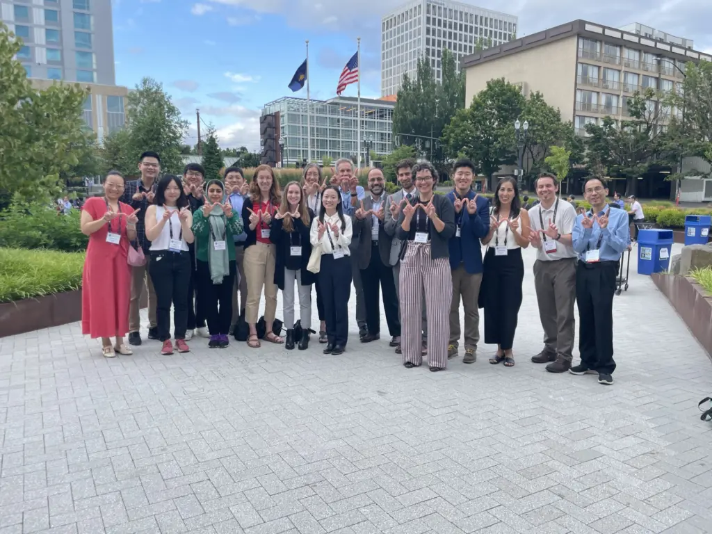 ECE students, faculty, and alumni at conference making "W" with hands