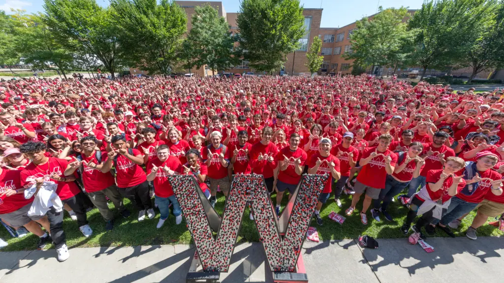 All engineering students giving W sign with hands outside of engineering hall