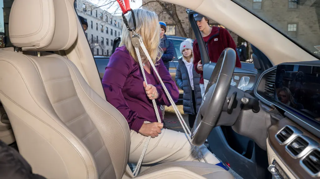 Kristan Collins uses a device a team of UW-Madison first-year engineering students created for her to assist with getting into her car.