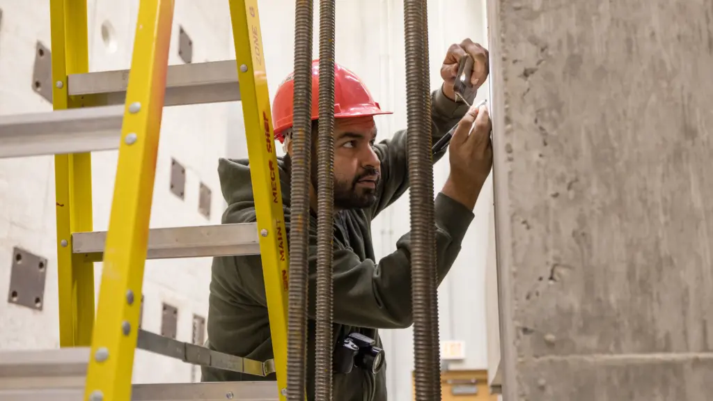 A CEE student checks a concrete specimen for cracks