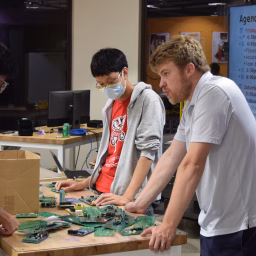 Assistant Professor Michael Biehler talks with students during the 2025 Hackathon/Makerthon.